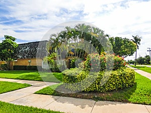 Typical Florida home in the countryside with palm trees, tropical plants and flowers