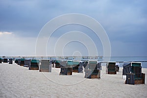 Typical german beach chairs or beach chairs baskets on the beach of Nord or Baltic sea in the evening