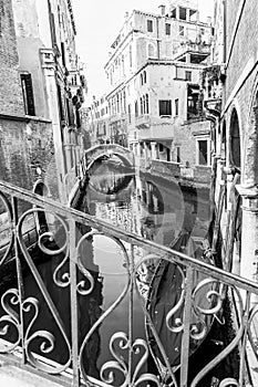 Typical Gondola in a narrow Venetian canal. Traditional italian architecture. Black and white image