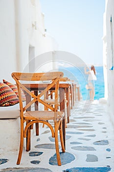 Benches with pillows in a typical greek outdoor cafe in Mykonos with amazing sea view on Cyclades islands