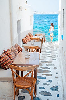 Benches with pillows in a typical greek outdoor cafe in Mykonos with amazing sea view on Cyclades islands