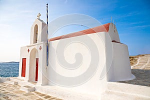 Typical Greek church white building with red dome against the blue sky on the island Mykonos, Greece