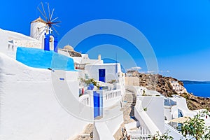 Typical Greek houses and windmill on street of Oia village, Santorini island, Greece