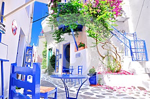 Typical greek traditional village in summer with white walls, blue furniture and colorful bougainvilla, Skiathos Island, Greece