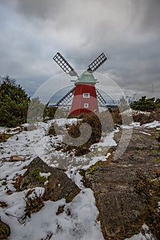 historical windmill made of red wood in a winter landscape.Stenungsund in Sweden photo