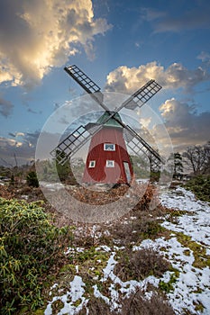 historical windmill made of red wood in a winter landscape.Stenungsund in Sweden photo