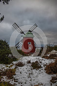 historical windmill made of red wood in a winter landscape.Stenungsund in Sweden photo