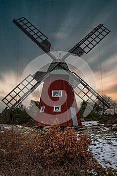 historical windmill made of red wood in a winter landscape.Stenungsund in Sweden photo