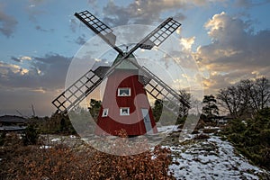 historical windmill made of red wood in a winter landscape.Stenungsund in Sweden photo