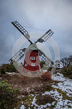 historical windmill made of red wood in a winter landscape.Stenungsund in Sweden photo