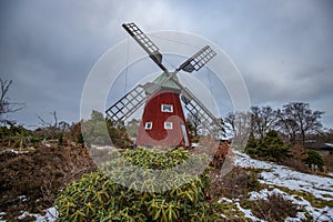 historical windmill made of red wood in a winter landscape.Stenungsund in Sweden photo