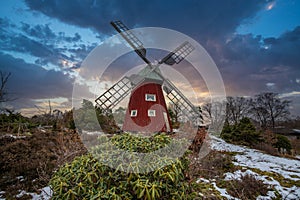 historical windmill made of red wood in a winter landscape.Stenungsund in Sweden photo