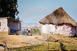 Typical house. African woman cleaning garden. South Africa
