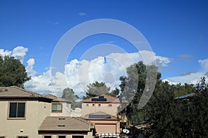 Typical house roofs under rising cumulus clouds