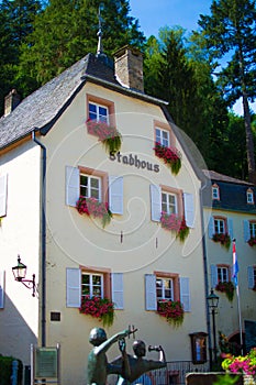 Typical house of Vianden Stadhous, in Luxembourg, with colorful flowers in the windows
