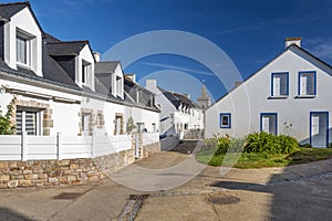 Typical houses in the village of Houat island in French Brittany. The top of Saint Gildas church is at background