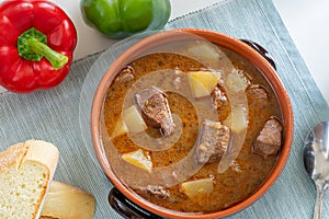 Typical Hungarian Goulash soup with rustic bread, top view