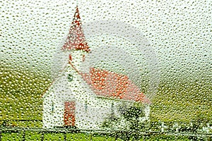Typical Icelandic church photographed through rainy window