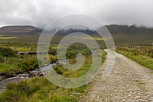 Typical Irirsh farm with road, stream and mountains