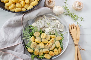 Typical Italian Gnocchi with mushroom sauce and arugula salad