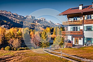 Typical italian house on the shore of Soraga lake. Bright morning cityscape of Soraga di Fassa village,