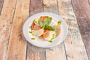 Typical Italian salad with buffalo cheese, tomato, basil, oil with parsley