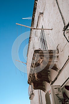 Typical Italian Street in Ostuni with a Balcony and Blue Sky Background