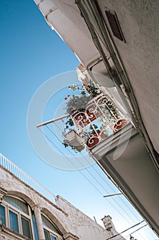 Typical Italian Street in Ostuni with a Balcony and Blue Sky Background