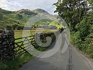 Typical Lake District scene of fields, dry stone wall and narrow road