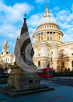 Typical London scene of St Paul`s Cathedral and an iconic red double decker bus in a bright sunny day