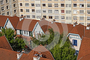 Typical and lovely houses surrounded by ugly and oppressive flat building, green lung in city