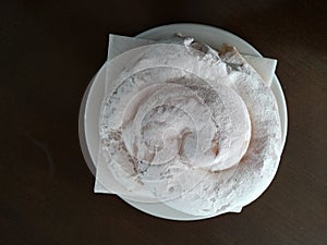 Typical Majorcan Ensaimada on a plate on a table photo