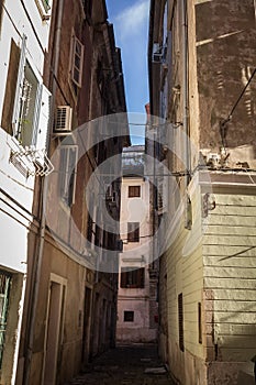 Typical mediterranean old narrow street with southern european architecture, with ancient buildings with balconies, in the old tow photo