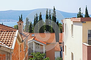 Typical Mediterranean urban landscape: houses with red tiled roof , green cypresses. Montenegro, Tivat town