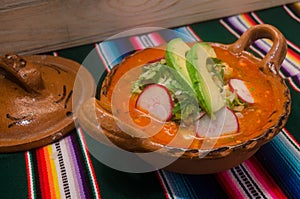 Traditional mexican pozole in clay dish photo