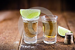 Typical mexican drinks, glass with tequila served with salt and lemon, next to a mezcal or mescal is commonly known as tequila