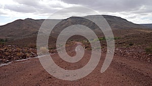 Typical namibian gravel road in namib desert. Sandy and rocky landscape.