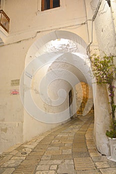 Typical narrow street with white walls in South Italy