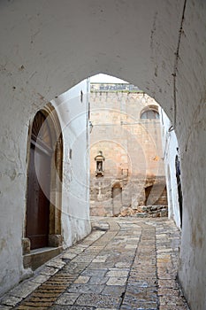 Typical narrow street with white walls in South Italy