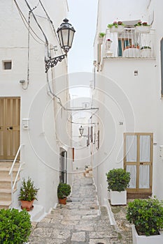 Typical narrow street with white walls in South Italy