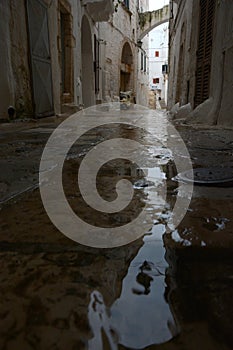 Typical narrow street with white walls in South Italy