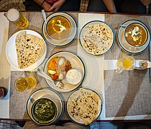 Typical nepalese meal and beer in Pokhara restaurant, Himalayas, Nepal. Assorted indian nepalese food on table. Dishes Nepal