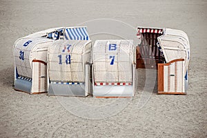 typical Northern German beach chairs, called Strandkorb, standing in a circle like a dare castle in the sand at the Baltic Sea, c