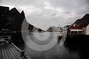 Typical Norwegian fishing village with traditional red rorbu huts, Reine, Lofoten Islands, Norway - fischer mole for boats