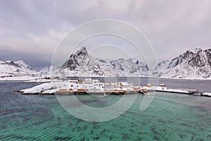 Typical Norwegian landscape. Beautiful view of scenic Lofoten Islands winter scenery with traditional yellow fisherman Rorbuer cab