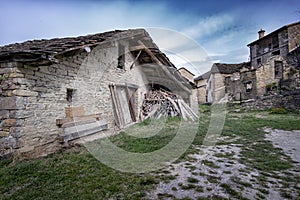 Typical old farm of the Pyrenees, borda, with a pile of wood stacked on the door