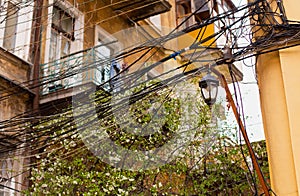 Typical old Odessa courtyard houses with dilapidated balconies, dirty yellow walls, bunch of electric wires and vintage