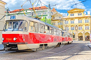 Typical old retro vintage tram on tracks near tram stop in the streets of Prague city near Sternberg palace