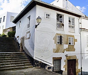 Typical old stone house and white walls with balconies and a lan