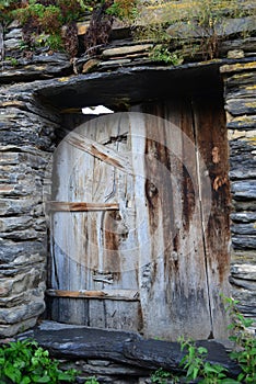 Typical old stone house and wooden door in Ushguli